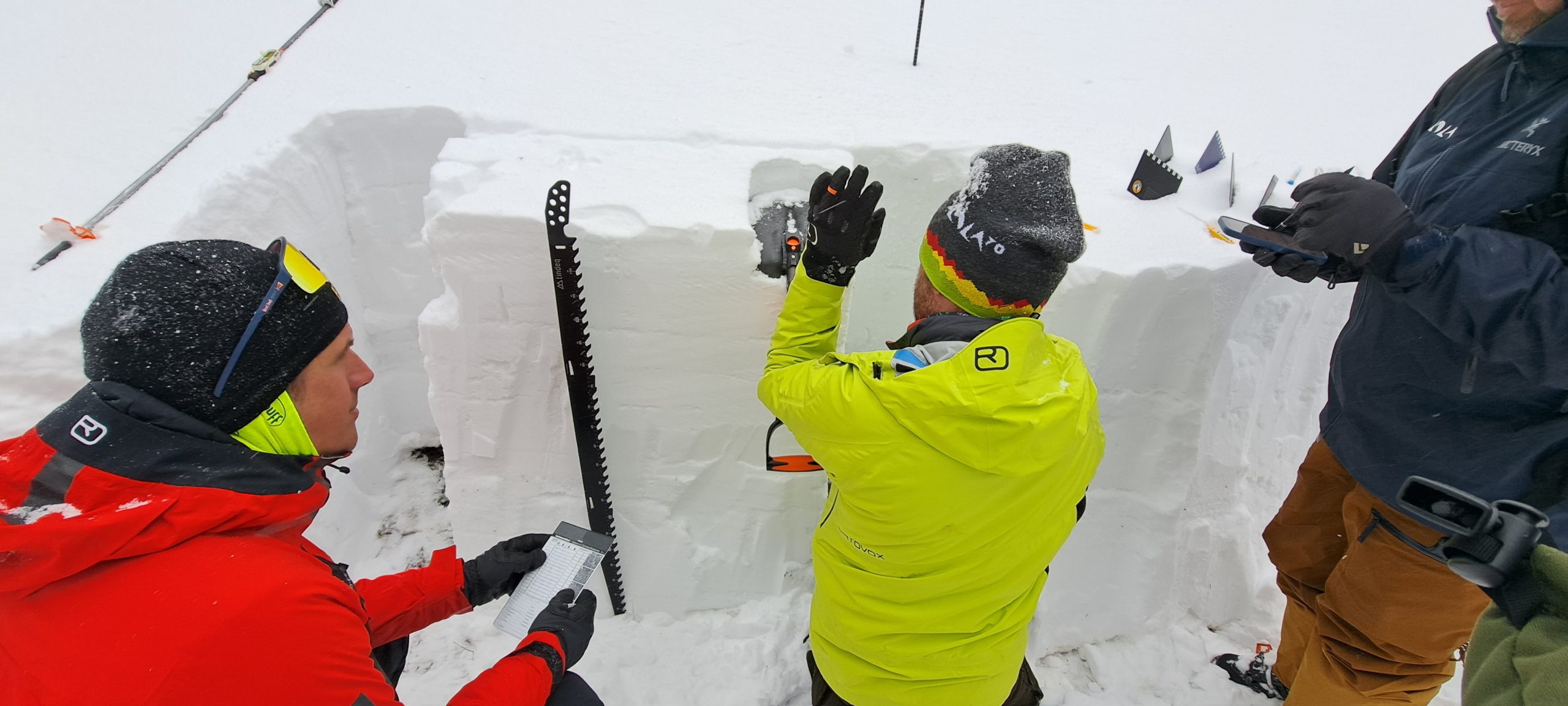 Kommissionsmitglieder bei ihrer Arbeit im Gelände bei Schneeprofilaufnahme und Schneedeckentests. © Lisa Pulling, GeoSphere Austria